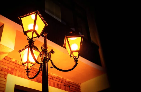 Oude gietijzeren lamp in de avond. — Stockfoto