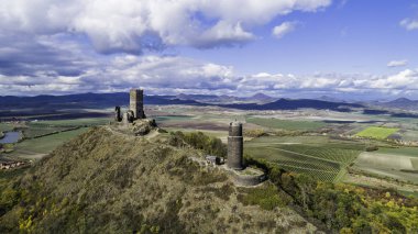 Hazmburk Şatosu. Ceske Stredohori dağının tepesindeki Hazmburk kalesinin kalıntıları. Çek Cumhuriyeti 'nin Klapy, Libochovice köyü yakınlarındaki Czech kırsal arazisi manzaralı ortaçağ kalesi.