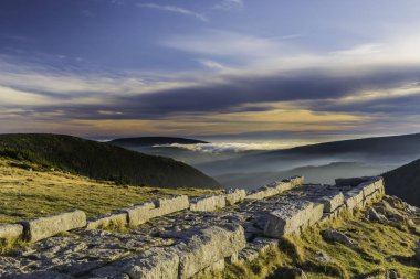 Karkonosze Ulusal Parkı, güzel bir sis manzarası ve batan güneşin bulutları.