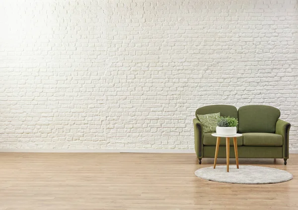 White brick wall background, green sofa and home object. - Stock Image -  Everypixel