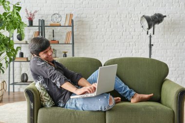 Evden, laptoptan ve müzik tarzından çalışan bir adam.