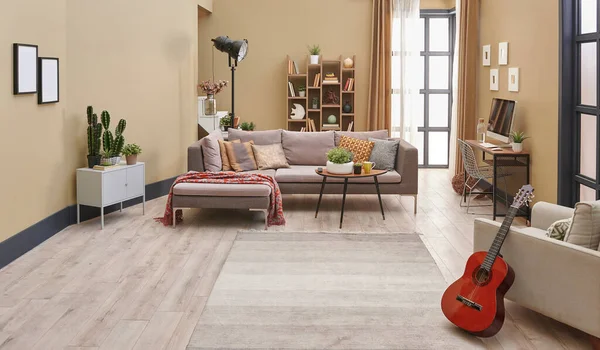 Kahverengi oturma odası, gri kanepe ahşap kitap ve halı ayrıntıları..