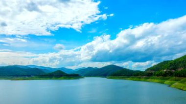 Bulutlar sakin göl üzerinde hareket.