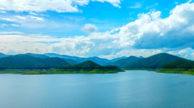 Bulutlar sakin göl üzerinde hareket.