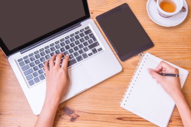 Dizüstü bilgisayar kullanan bir genç iş kadını.