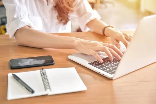 Joven mujer de negocios usando portátil en su escritorio — Foto de Stock