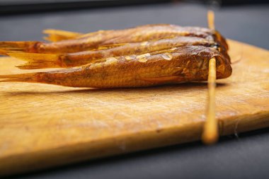 Masadaki ahşap bir tahtanın üzerinde kurumuş kefal. Balık ve deniz ürünleri mutfağı. Lezzetli..