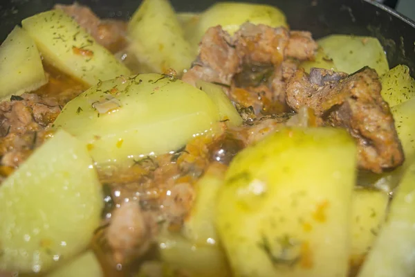 Meat with onions, carrots and potatoes stewed in a saucepan. Home cooking. Close up. — Stock Photo, Image