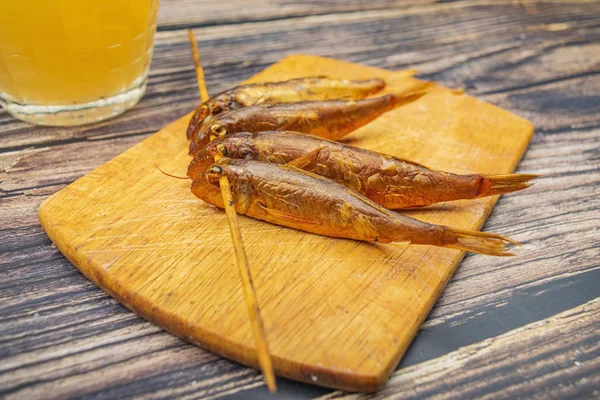 Salmonete seco en un tablero de madera con una taza de cerveza en la mesa. Cocina de pescado y marisco. Sabroso bocadillo . — Foto de Stock