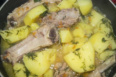 Patates, soğan, havuç ve tencerede dereotlu domuz pirzolası. Kapatın. Geleneksel tarif. Ev yemeği..