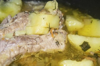 Patates, soğan, havuç ve tencerede dereotlu domuz pirzolası. Kapatın. Geleneksel tarif. Ev yemeği..