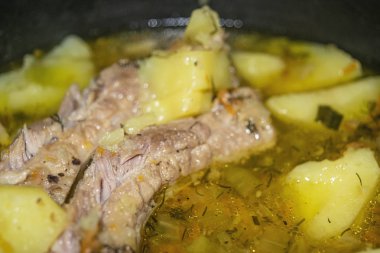 Patates, soğan, havuç ve tencerede dereotlu domuz pirzolası. Kapatın. Geleneksel tarif. Ev yemeği..