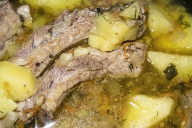 Patates, soğan, havuç ve tencerede dereotlu domuz pirzolası. Kapatın. Geleneksel tarif. Ev yemeği..