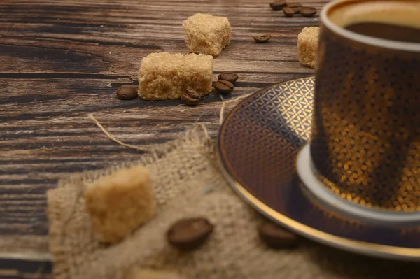 Кубок кофе, коричневый сахар и кофейная фасоль на деревянном фоне. Закрыть . — стоковое фото