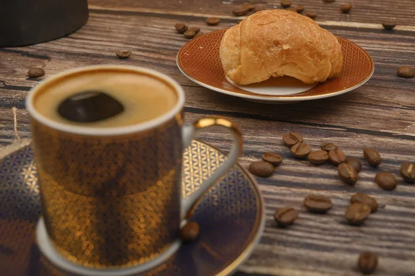 Kaffeetasse, Croissants und Kaffeebohnen auf Holzgrund. Nahaufnahme. — Stockfoto