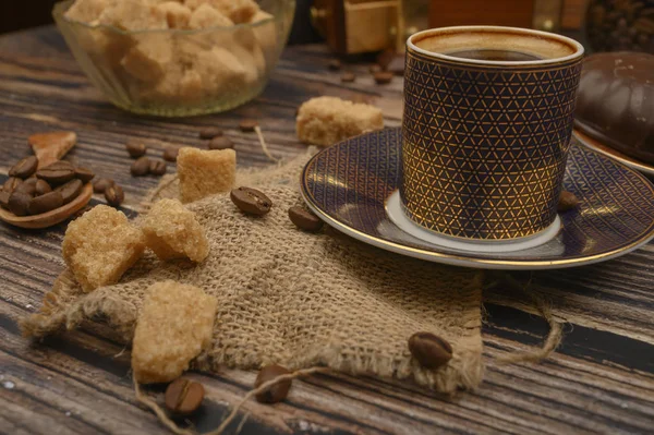 Tazza di caffè, chicchi di caffè, zucchero di canna su sfondo di legno. Da vicino. . — Foto Stock