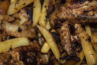 Patatesli tavada kızartılmış baharatla marine edilmiş tavuk kanatları. Ev yemeği.