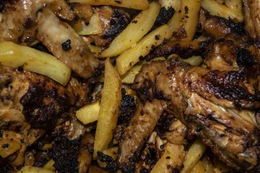 Patatesli tavada kızartılmış baharatla marine edilmiş tavuk kanatları. Ev yemeği.