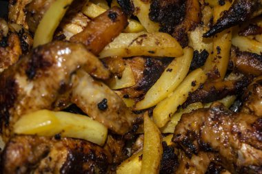 Patatesli tavada kızartılmış baharatla marine edilmiş tavuk kanatları. Ev yemeği.