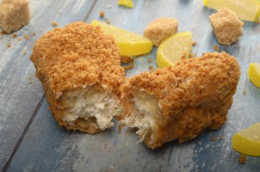 Kırık bir pasta, kahverengi şeker ve marmelatlı limon dilimleri ahşap arka planda..