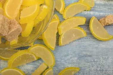 Marmelat limon dilimleri ve tahtadan bir arka planda esmer şeker parçaları. Tatlı tatlı. Kapat..