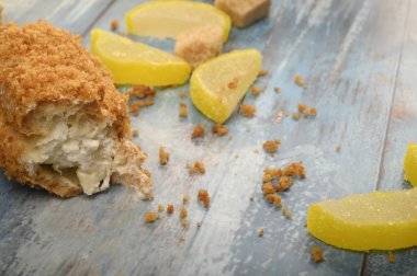 Kırık bir pasta, kahverengi şeker ve marmelatlı limon dilimleri ahşap arka planda..