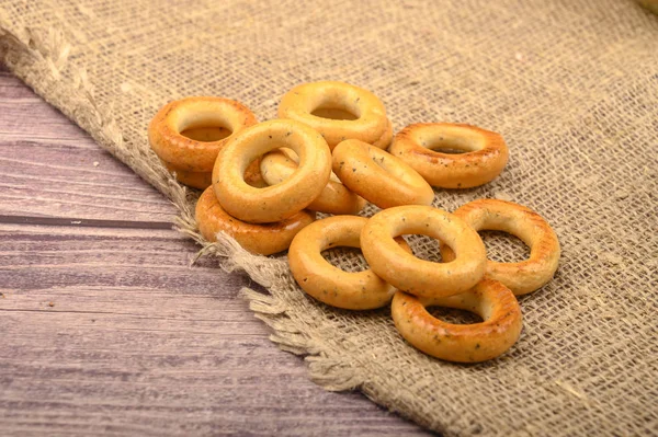 Piccoli bagel su uno sfondo di tessuto homespun ruvido primo piano . — Foto Stock