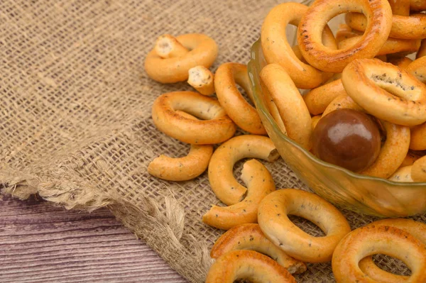 Pequenos bagels, açúcar mascavo e pratos de cerâmica em um fundo de madeira close-up . — Fotografia de Stock