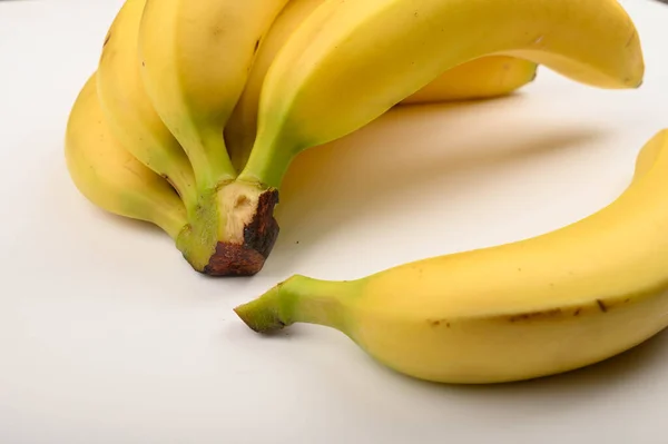 Banda dojrzałych, żółtych bananów na białym tle. Zamknij się.. — Zdjęcie stockowe