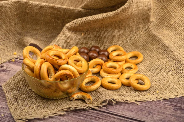 Pequeno bagels e chocolates em um contexto de tecido de casa áspero close-up . — Fotografia de Stock