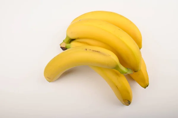 Banda dojrzałych, żółtych bananów na białym tle. Zamknij się.. — Zdjęcie stockowe