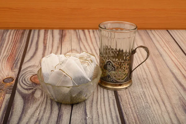 Kantong teh di vas kaca dan kaca berwajah kosong di tempat penyimpanan Piala antik dengan latar belakang kayu. Tutup. . — Stok Foto
