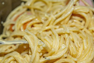 Soslu haşlanmış spagetti ve bir tabakta parçalanmış haşlanmış sosis. Kapat.