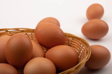 Hasır bir sepette beyaz bir arka planda tavuk yumurtası. Kapat.