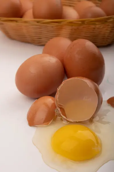 Разбитое Куриное Яйцо Куриные Яйца Плетеной Корзине Яйца Разбросанные Белом — стоковое фото
