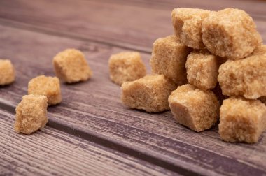 Tahta bir arka planda kahverengi şeker yığını. Kapat.