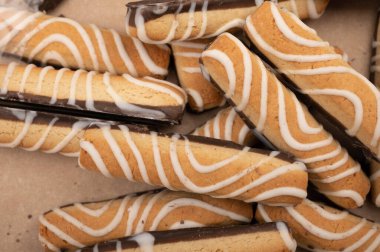 Çikolata ve beyaz kremayla kaplı kurabiye çubukları. Kapat.