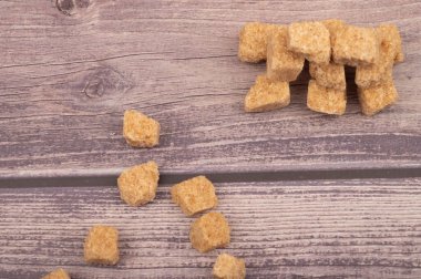 Tahta arka planda kahverengi kamış şekeri parçaları. Kapat.