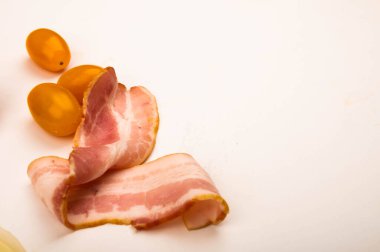 Beyaz arka planda dilimlenmiş pastırma ve domates. Kapat.