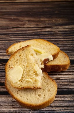 Tahta arka planda tereyağlı taze buğday tostu. Kapat.