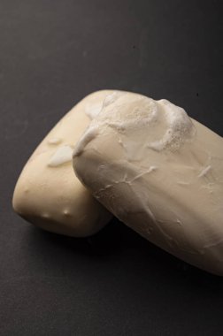 Siyah arka planda iki parça tuvalet sabunu. Kapatın. Sabunla düzenli el yıkama COVID-19 enfeksiyonunun önlenmesidir.