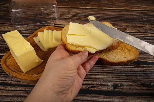 Ktoś Rozsypuje Masło Świeżym Toście Pszennym Nożem Drewnianym Masłem Kawałkiem — Zdjęcie stockowe