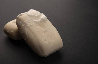 Siyah arka planda iki parça tuvalet sabunu. Kapatın. Kişisel hijyen kurallarına uymak COVID-19 enfeksiyonunun önlenmesidir.