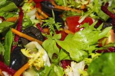 Sebze salatası dilimlenmiş domates, havuç, pancar, marul, roka ve zeytin. Arkaplan resmini kapat