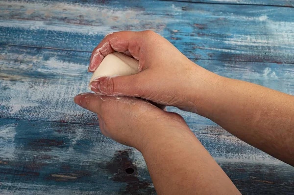 Someone is soaping their hands with a piece of toilet soap on a wooden background. Close up. Washing hands with soap is a prevention of COVID-19 infection