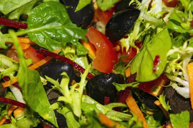 Sebze salatası dilimlenmiş domates, havuç, pancar, marul, roka ve zeytin. Arkaplan resmini kapat