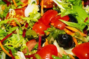 Sebze salatası dilimlenmiş domates, havuç, pancar, marul, roka ve zeytin. Arkaplan resmini kapat.