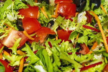 Sebze salatası dilimlenmiş domates, havuç, pancar, marul, roka ve zeytin. Arkaplan resmini kapat