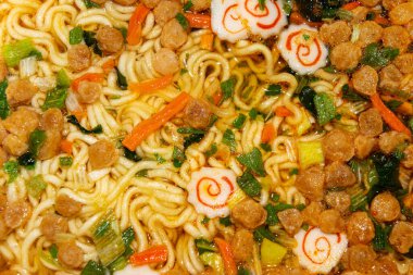 Baharatlı erişte, kurutulmuş sebze ve kaynar suyla doldurulmuş dondurulmuş et. Kapat.