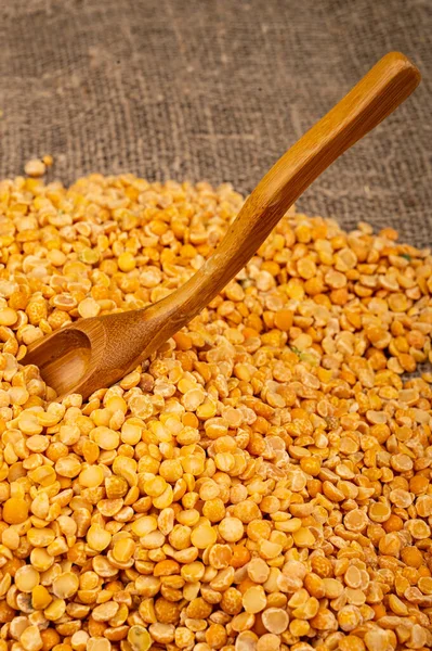 Yellow split peas scattered on a background of coarse-textured burlap. Traditional cereals for making soups and porridge. Close up — Stock Image Yellow Split Peas Scattered Background Coarse Textured Burlap Traditional Cereals Royalty Free Stock Photos